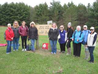 Group photo with the sign identifying the Wolf Run State Park Fly In Camp Area.