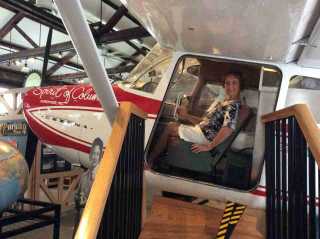 Museum hostess seated in cockpit replica