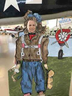 A 99 with her face inserted into a cutout of an old-time aviator